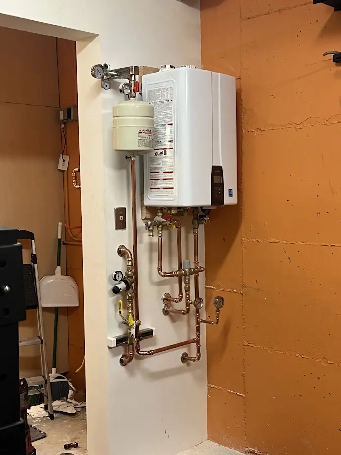 Plumbing technician inspecting water heater connections in Montevallo